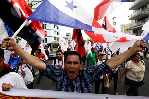 A demonstrator holds up a Panamanian flag during a protest by the "Cumbre de los Pueblos" or "People's Summit," against U.S. policies in Latin America, Panama City, April 9, 2015 (AP photo by Arnulfo Franco).
