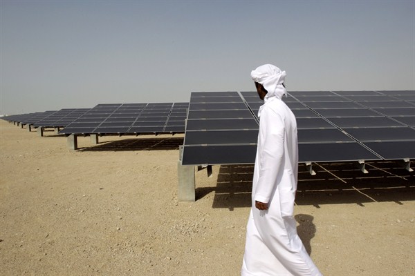An Emirati man walks by a photovoltaic plant at Masdar City, Abu Dhabi, United Arab Emirates, Jan. 16, 2011 (AP photo by Kamran Jebreili).