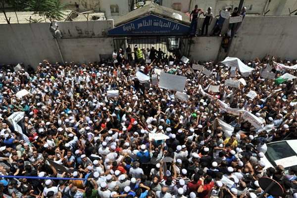 Demonstrators of the Berber community stage a protest in front of a walled area where Algier's newspapers are headquartered, Algiers, July 8, 2015 (AP photo by Sidali Djarboub).