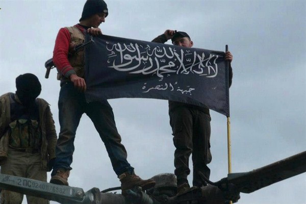 Rebels from al-Qaida-affiliated Jabhat al-Nusra on top of a Syrian air force helicopter, Idlib, Syria, Jan. 11, 2013 (AP photo by Edlib News Network).