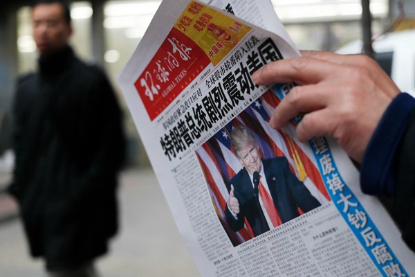 A man reads a newspaper announcing Donald Trump's election victory, Beijing, China, Nov. 10, 2016 (AP photo by Andy Wong).