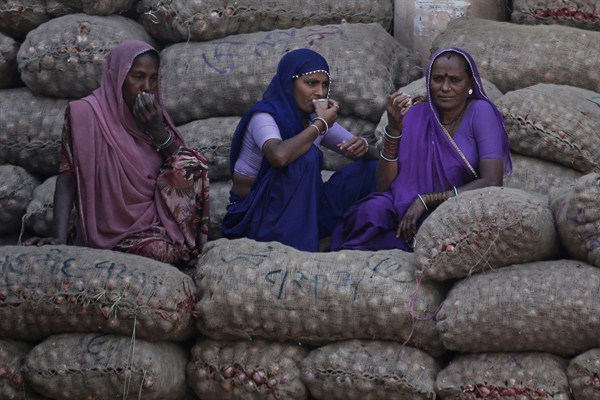 Women laborers take a break at an agriculture market, Ahmadabad, India, Nov. 23, 2016 (AP photo by Ajit Solanki).