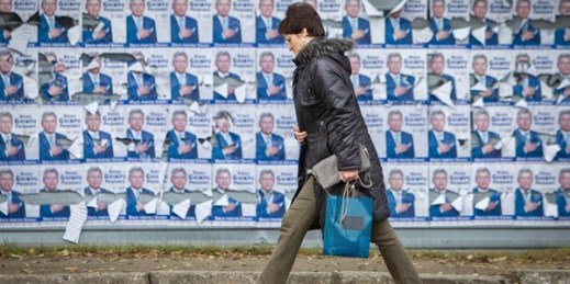 A woman walks by electoral posters in Chisinau, Moldova, Oct. 27, 2016 (AP photo by Roveliu Buga).