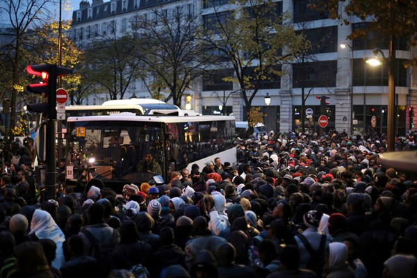 Migrants wait to board buses to temporary shelters, Paris, Friday, Nov. 4, 2016 (AP photo by Thibault Camus).