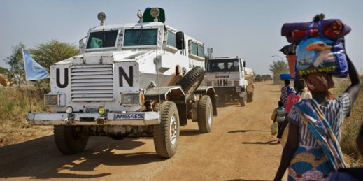 A United Nations armored vehicle passes displaced people near a U.N. camp, Malakal, South Sudan, Dec. 30, 2013 (AP photo by Ben Curtis).