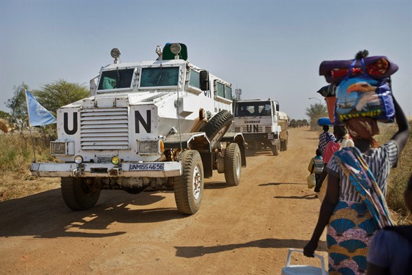 A United Nations armored vehicle passes displaced people near a U.N. camp, Malakal, South Sudan, Dec. 30, 2013 (AP photo by Ben Curtis).