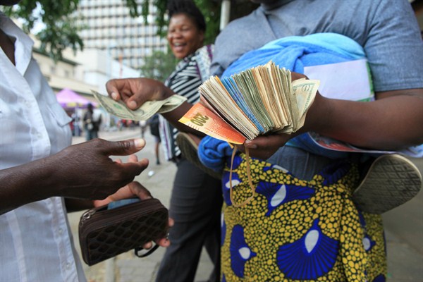 A currency trader performs a transaction, Harare, Zimbabwe, Oct. 28, 2016 (AP photo by Tsvangirayi Mukwazhi).
