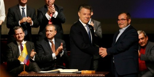 Colombian President Juan Manuel Santos shakes hands with FARC leader Rodrigo Londono at the signing ceremony for a revised peace pact, Bogota, Colombia, Nov. 24, 2016 (AP photo by Fernando Vergara).