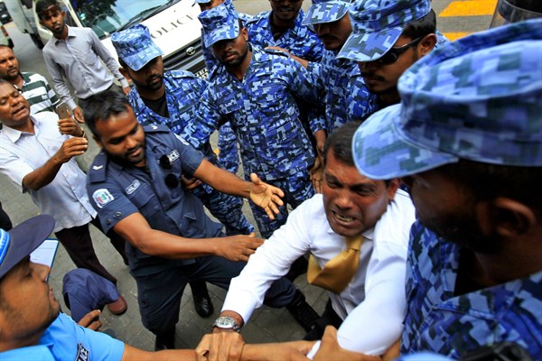Former Maldives President Mohamed Nasheed, in white, tussles with policemen who stopped him from speaking to journalists, Male, Maldives, Feb. 23, 2015 (AP photo by Sinan Hussain).