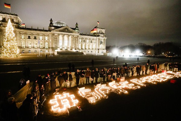 Activists light candles to spell the phrase "Safe Passage" in remembrance of the migrants who died in the Mediterranean Sea in front of the German parliament, Berlin, Dec. 15, 2016 (AP photo by Markus Schreiber).