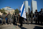 Israeli border police officers next to a supporter of Sgt. Elor Azaria during a demonstration by hardline nationalists outside the Israeli military court, Tel Aviv,  Jan. 4, 2017 (AP photo by Oded Balilty).