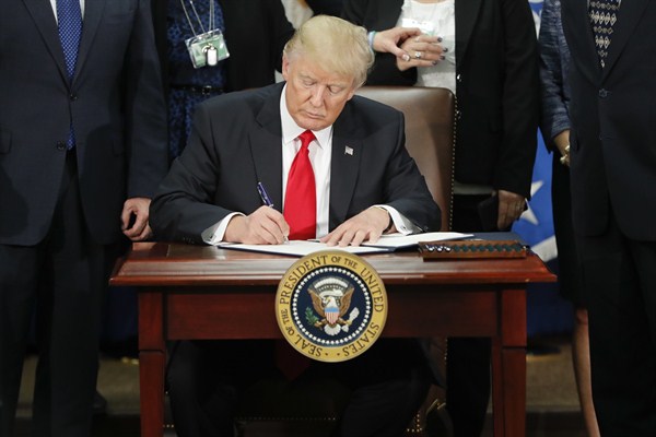 President Donald Trump signs an executive order for border security and immigration at the Department of Homeland Security, Washington, Jan. 25, 2017 (AP photo by Pablo Martinez Monsivais).