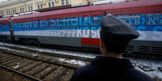 A railroad worker stands by a train decorated with letters that read "Kosovo is Serbian" written in twenty languages, Belgrade, Serbia, Jan. 14, 2017 (AP photo by Darko Vojinovic).