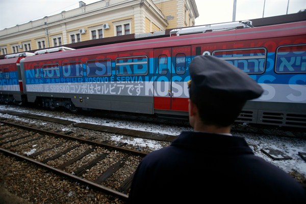 A railroad worker stands by a train decorated with letters that read "Kosovo is Serbian" written in twenty languages, Belgrade, Serbia, Jan. 14, 2017 (AP photo by Darko Vojinovic).