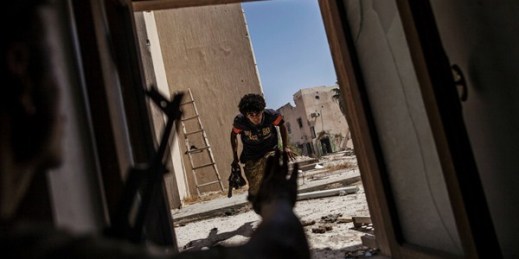 A fighter from the Libyan forces affiliated with the Tripoli government runs for cover while fighting against Islamic State positions, Sirte, Sept. 22, 2016 (AP photo by Manu Brabo).