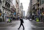 A man crosses a main avenue during a full-day general strike, Montevideo, Uruguay, Aug. 6, 2015 (AP photo by Matilde Campodonico).