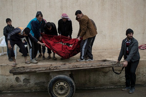 Relatives and friends carry the body of a man killed by a sniper while trying to flee fighting between Iraqi security forces and Islamic State militants, Mosul, Iraq, March 23, 2017 (AP photo by Felipe Dana).