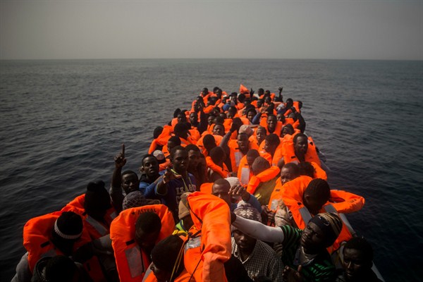 African refugees and migrants, mostly from Sudan and Senegal, wait aboard a rubber boat to be assisted by an NGO, off the Libyan coast, Feb. 23, 2016 (AP photo by Santi Palacios).