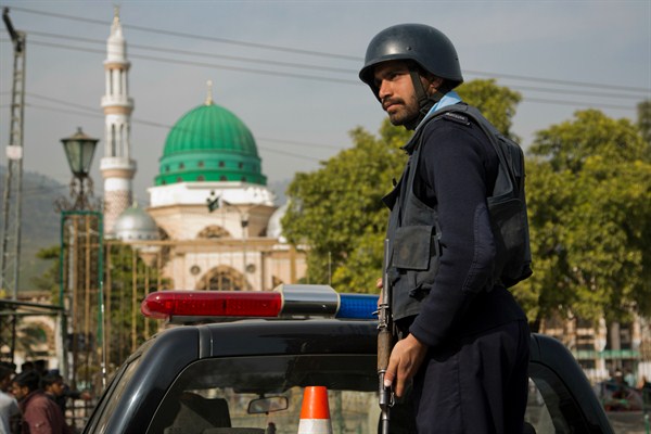 A Pakistani police officer on guard outside the Barri Imam shrine in Islamabad, following a suicide attack at a Sufi shrine in Sindh province, Feb. 17, 2017 (AP photo by B.K. Bangash).