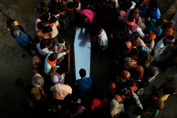 Relatives and villagers gather around the coffin of Balkisun Mandal Khatwe, who died while working as a migrant in Qatar, Saptari, Nepal, Nov. 23, 2016 (AP photo by Niranjan Shrestha).
