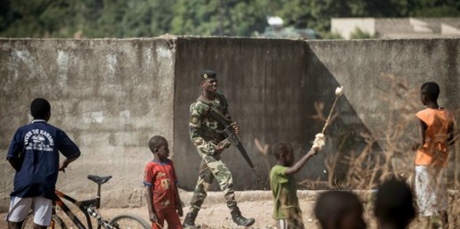A Senegalese soldier passes local children near Gambia's border with Senegal, Jan. 20, 2017 (AP photo by Sylvain Cherkaoui).