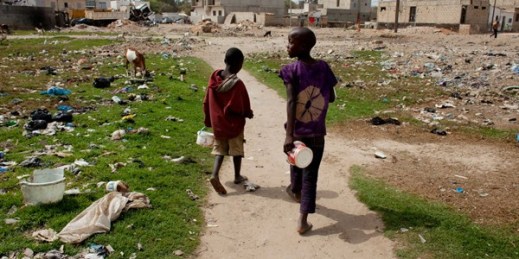 Talibe students walk in a field littered with garbage, Dakar, Senegal, April 20, 2015 (AP photo by Jane Hahn).