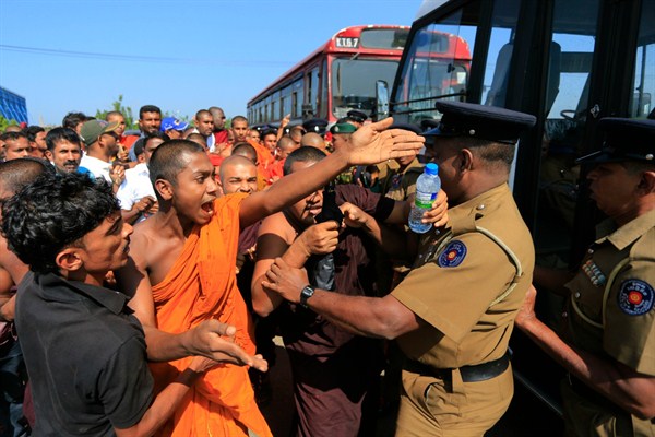 A Buddhist monk and villagers argue with police officers during a protest outside the inauguration ceremony of an industrial zone, Ambalantota, Hambantota district, Sri Lanka, Jan. 7, 2017 (AP photo by Eranga Jayawardena).