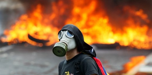 An anti-government protester in front of a burning barricade, Caracas, Venezuela, April 24, 2017 (AP photo by Ariana Cubillos).