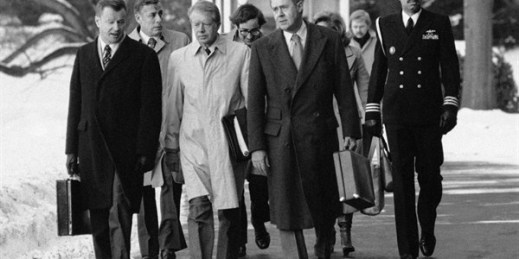 Zbigniew Brzezinski, left, walks with U.S. President Jimmy Carter and Secretary of State Cyrus Vance toward a helicopter to fly to Andrews Air Force Base, Feb. 14, 1979 (AP photo by Bob Daugherty).