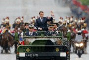 French President Emmanuel Macron waves from a military vehicle as he rides on the Champs Elysees avenue toward the Arc de Triomphe, Paris, France, May 14, 2017 (AP photo by Michel Euler).