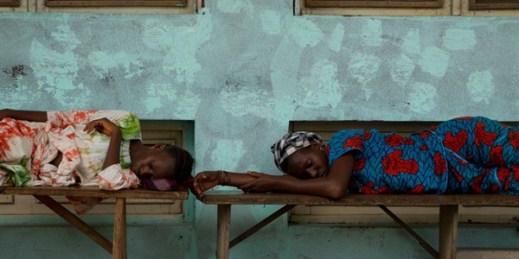 Women sleep on benches outside a hospital, Gabu, Guinea-Bissau, May 21, 2012 (AP photo by Rebecca Blackwell).