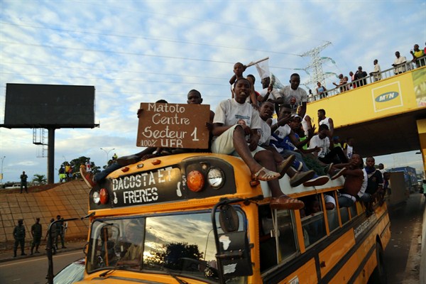 Guineans ride on the back of a bus during a political rally, Conakry, Guinea, Oct. 7, 2015 (AP photo by Youssouf Bah).