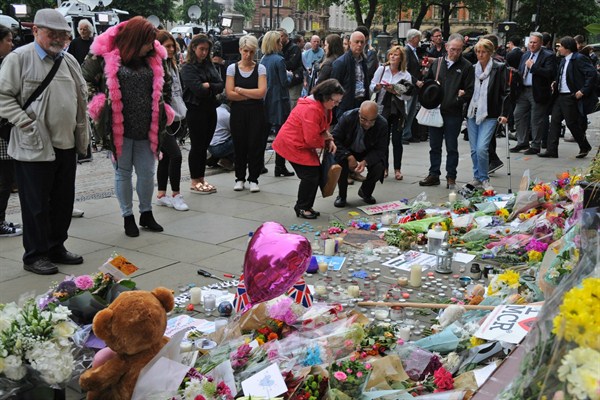 People gather in Manchester's Albert Square to view flower tributes to those killed in an explosion at an Ariana Grande concert, Manchester, England, May 24, 2017 (AP photo by Rui Vieira).