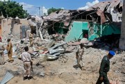 Soldiers look at the destroyed houses amid the wreckage of a car bombing in Somalia, one of the world's most fragile states, Mogadishu, May 17, 2017 (AP photo by Farah Abdi Warsameh).