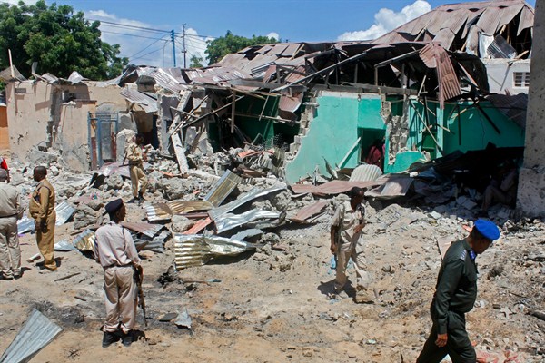 Soldiers look at the destroyed houses amid the wreckage of a car bombing in Somalia, one of the world's most fragile states, Mogadishu, May 17, 2017 (AP photo by Farah Abdi Warsameh).