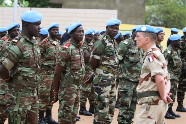 A French soldier stands alongside troops who helped France take back Mali’s north as they participate in a ceremony formally transforming the force into a United Nations peacekeeping mission, Bamako, Mali, July 1, 2013 (AP photo by Harouna Traore).