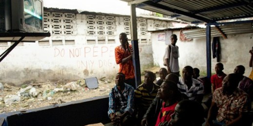 Men watch the announcement of a ruling on an appeal bid by former Liberian President Charles Taylor, Monrovia, Liberia, Sept. 26, 2013 (AP photo by Mark Darrough).