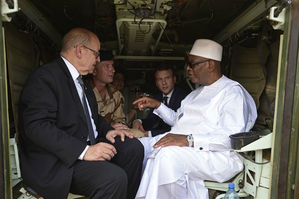Mali’s president, Ibrahim Boubacar Keita, speaks with French Foreign Minister Jean-Yves Le Drian and French President Emmanuel Macron during their visit with soldiers from Operation Barkhane, Gao, Mali, May 19, 2017 (AP photo by Christophe Petit).