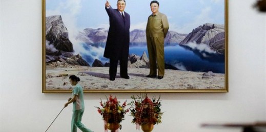 A hotel staff member mops the floor in front of a picture featuring portraits of the late North Korean leaders Kim Il Sung, left, and Kim Jong Il, Pyongyang, North Korea, June 19, 2017 (AP photo by Wong Maye-E).