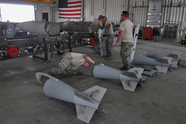 Members of a U.S. Air Force munitions team assemble guided bombs to support the 379th Air Expeditionary Wing, al-Udeid Air Base, Qatar, March 10, 2015 (AP photo by Adam Schrek).