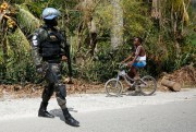A boy bikes past a U.N. soldier from Brazil on the road between Port-au-Prince and Les Cayes, Haiti, Oct. 15, 2016 (AP photo by Rebecca Blackwell).