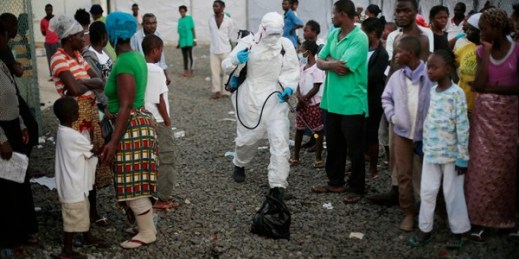 A medical worker sprays people being discharged from the Island Clinic Ebola treatment center, Monrovia, Liberia, Sept. 30, 2014 (AP photo by Jerome Delay).