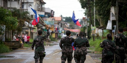 Philippine National Police hang flags in a part of the war-torn city of Marawi ahead of Independence Day celebrations, June 11, 2017 (NurPhoto by Richard Atrero de Guzman via AP).