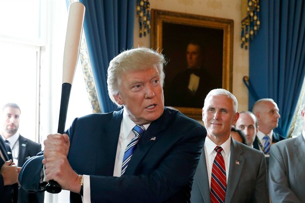 President Donald Trump prepares to swing a Marucci bat, from Baton Rouge, La., as Vice President Mike Pence looks on during a "Made in America" product showcase at the White House, Washington, July 17, 2017 (AP photo by Alex Brandon).