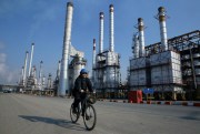 An Iranian oil worker rides his bicycle at the Tehran oil refinery south of Tehran, Iran, Dec. 22, 2014 (AP photo by Vahid Salemi).