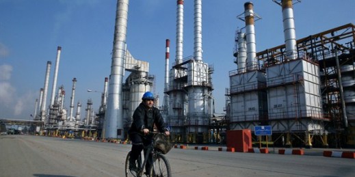 An Iranian oil worker rides his bicycle at the Tehran oil refinery south of Tehran, Iran, Dec. 22, 2014 (AP photo by Vahid Salemi).