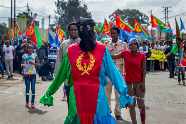 A woman dressed in the colors of the Eritrean flag stands chained at a demonstration by Eritrean refugees and dissidents, Addis Ababa, Ethiopia, June 23, 2016 (AP photo by Mulugeta Ayene).