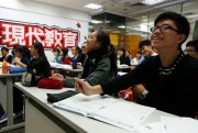 Students laugh during an English grammar lesson taught by a "celebrity tutor" in Hong Kong, Dec. 9, 2013 (AP photo by Kin Cheung).