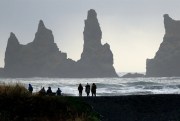 People walk on a beach near the volcano Katla, a tourism hotspot, Vik, Iceland, Oct. 26, 2016 (AP photo by Frank Augstein).
