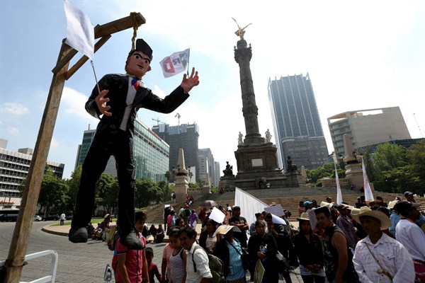 An effigy of Mexican President Enrique Pena Nieto hangs from a mock gallows set up by protesting farmers at the foot of the Angel of Independence monument in Mexico City, Aug. 7, 2017 (AP photo by Gustavo Martinez Contreras).